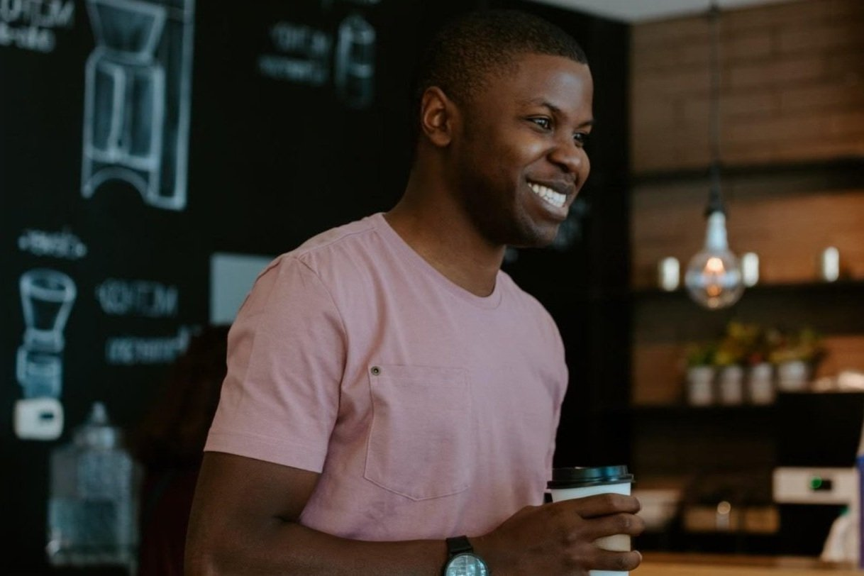 A smiling man enjoying a coffee in a cafe